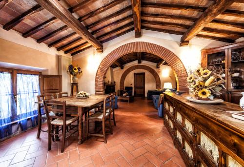 a kitchen with a table and chairs in a room at Fonte Del Castagno in Sinalunga