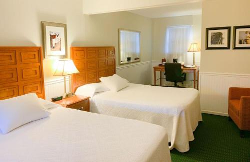 a hotel room with two beds and a desk at Cedar Crest Inn in Camden