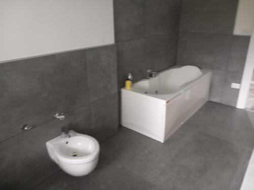 a bathroom with a toilet and a tub and a sink at Attico Marsiglie in Casal Fiumanese