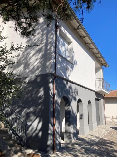 Une église blanche avec un arbre devant elle dans l'établissement Attico Marsiglie, à Casal Fiumanese