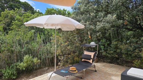 a chair sitting under an umbrella on a patio at Sardinian Seaside Retreats in Badesi
