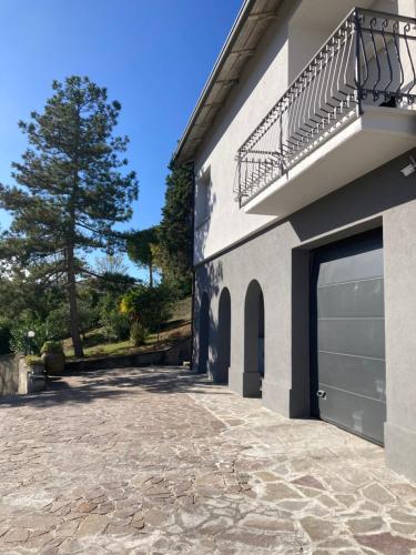 Casal Fiumanese的住宿－Attico Marsiglie，一座带车库门和一棵树的建筑