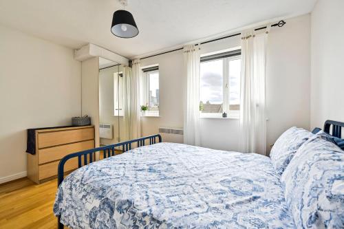 1 dormitorio con 1 cama, vestidor y ventanas en River views from Canary Wharf en Londres