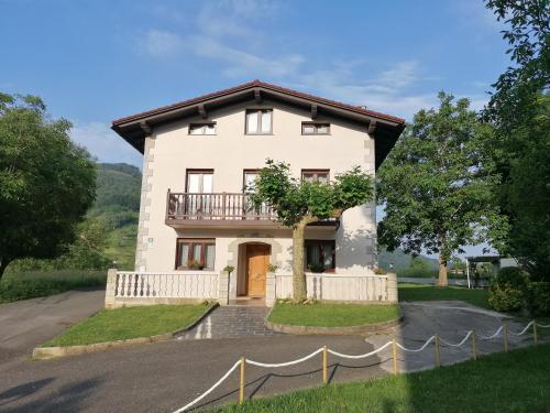 a large white house with a driveway at Gaiko Etxe Berri in Aizarnazábal