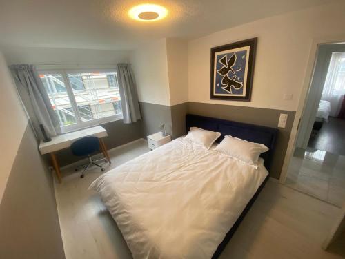 a bedroom with a white bed and a window at Cozy Escape House 12 min away from Zurich Main Station in Ober Urdorf