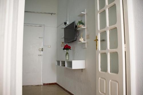 a room with a door and a television on a wall at La Vague de Jasmin in Gabès