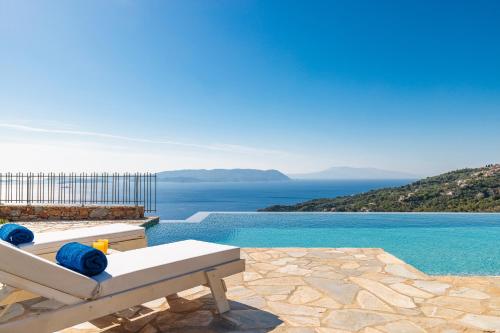 a bench sitting on a patio with a view of the water at RODON Luxury Villas in Skopelos Town