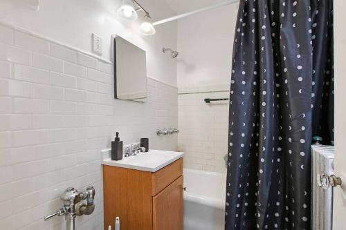 baño con lavabo y cortina de ducha en Stylish Studio Apartment in Evanston - Elmgate Manor 419, en Evanston
