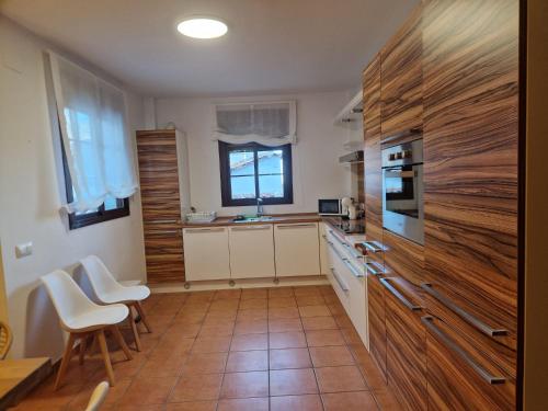una cocina con armarios de madera y electrodomésticos blancos en La Magia de Grazalema, en Grazalema