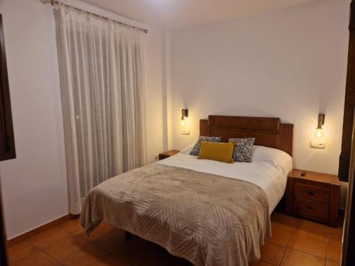 a bedroom with a large bed and a window at La Magia de Grazalema in Grazalema