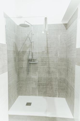 una ducha con puerta de cristal en un baño en B&B Art, en Reggio Calabria