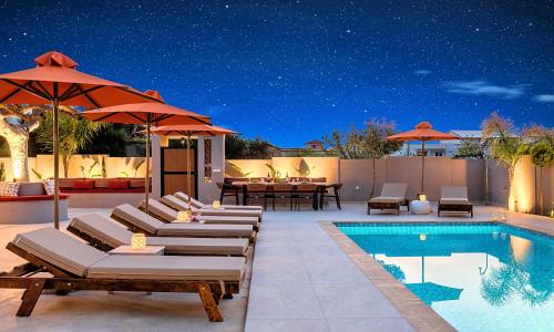 a patio with lounge chairs and a swimming pool at Villa Remezzo Heated Pool, Beach Side in Georgioupoli
