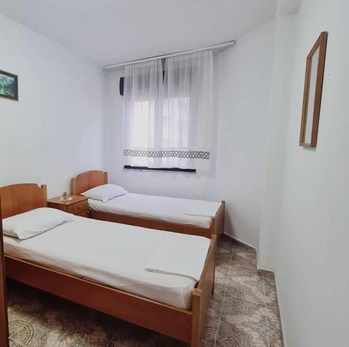 twee bedden in een kamer met een raam bij Apartment Durres in Durrës