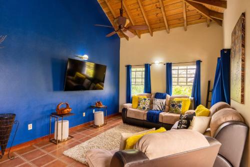 una sala de estar con paredes azules y sofás en The vintage charm, en Cliftons