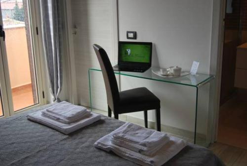 1 dormitorio con escritorio, ordenador y cama en Le Mulinare - Bed & Breakfast, en Drapia
