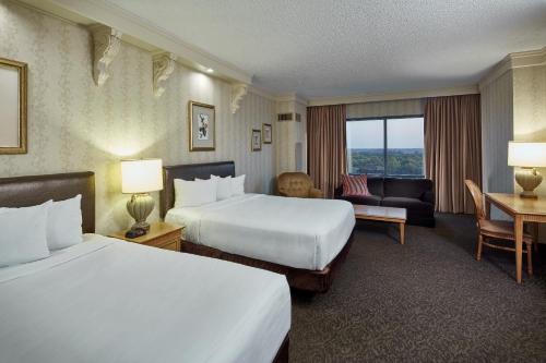 a hotel room with two beds and a desk at Horseshoe Tunica Casino & Hotel in Tunica Resorts