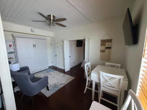 sala de estar con mesa, sillas y ventilador de techo en Duval Street Suite w parking and heated pool, en Key West