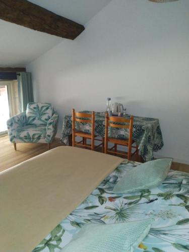 Habitación con cama, mesa y sillas. en A la maison du bonheur, en Lanty-sur-Aube