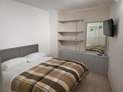 a bedroom with a bed and a tv and a mirror at Brezza Marina in Riomaggiore