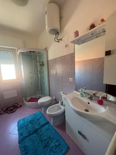 ein Badezimmer mit einem Waschbecken, einem WC und einem Spiegel in der Unterkunft Casa vacanza Alcamo Marina in Alcamo