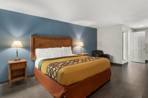 1 dormitorio con 1 cama grande y pared azul en Americas Best Value Inn Carlisle, en Carlisle