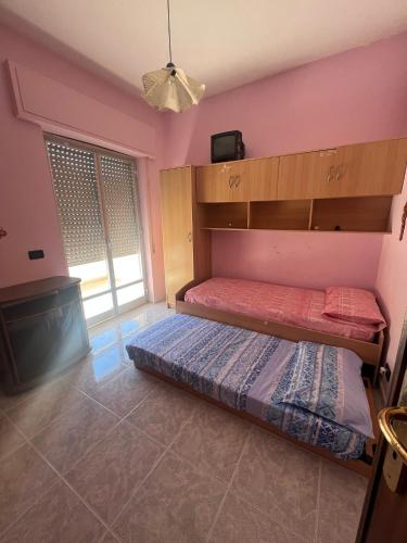 Schlafzimmer mit einem Bett und einem Flachbild-TV in der Unterkunft Casa vacanza Alcamo Marina in Alcamo