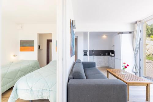 1 dormitorio y sala de estar con sofá y cama en Casa Mediterrani & piscina comunitaria junto Barcelona, en Alella
