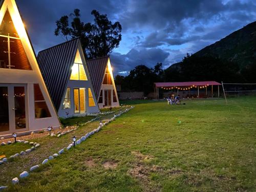 een huis op een veld 's nachts met een tent bij Vallecito Lodge in Muyurina