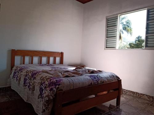 una camera con un letto in una stanza con una finestra di Canto dos Pássaros- Casa de campo em Gonçalves a Gonçalves