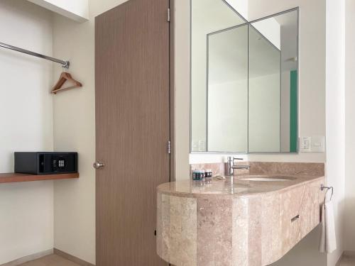 a bathroom with a marble sink and a mirror at Siente Tulum in Tulum