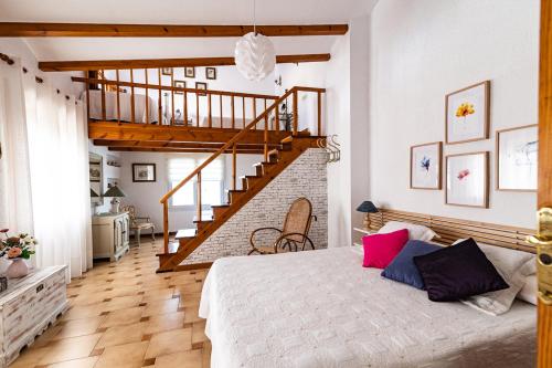 a bedroom with a bed and a staircase at La Venta Casa Rural in Benitachell