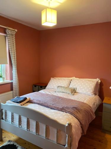 - une chambre avec un lit aux murs orange dans l'établissement Shannon Park House, à Sligo