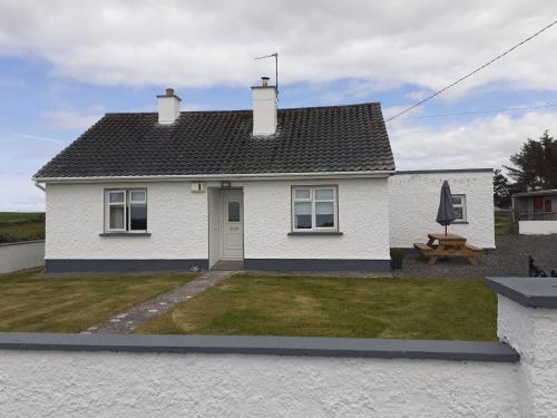 a white house with a picnic table in the yard at Shannon Park House in Sligo