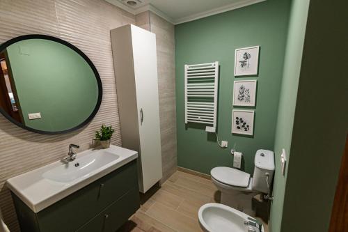 a bathroom with a sink and a mirror and a toilet at La Venta Casa Rural in Benitachell