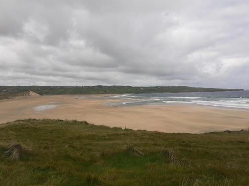 a sandy beach with the ocean on a cloudy day at Shannon Park House in Sligo