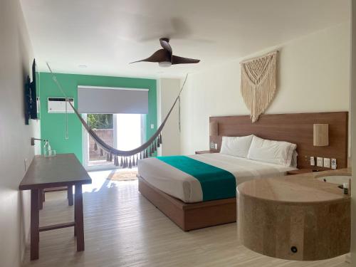 een slaapkamer met een bed en een plafondventilator bij Siente Tulum in Tulum