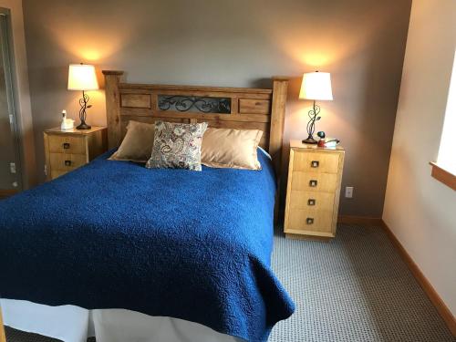 Tumalo的住宿－Rocking CR Ranch Guesthouse，一间卧室配有蓝色的床和2个床头柜