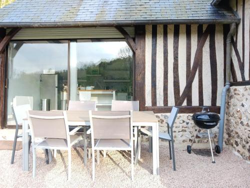 une table et des chaises devant une maison dans l'établissement Gite La Vieille Rivière, à Genneville