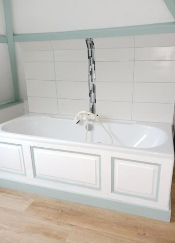La salle de bains est pourvue d'une baignoire blanche avec un robinet. dans l'établissement Gite La Vieille Rivière, à Genneville