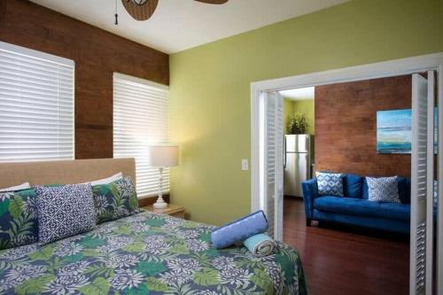 een slaapkamer met een bed en een blauwe bank bij Two Duval Street Suites w pool in Key West