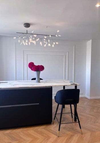 une table avec un vase de fleurs et une chaise dans l'établissement Elena Gestion, à Marseille