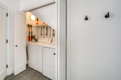 a kitchen with white cabinets and a washer and dryer at Family Friendly Modern Cabin in Munds Park! in Munds Park