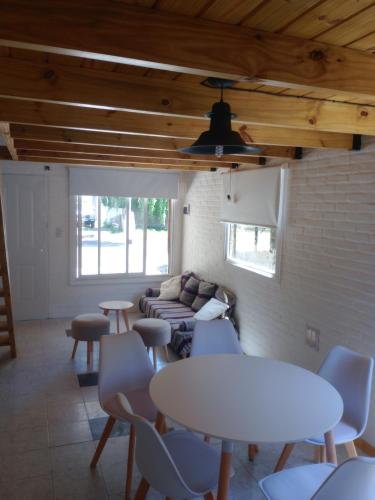 een kamer met een tafel en stoelen en een bank bij Duplex en Santa Clara para 4/5 personas in Santa Clara del Mar