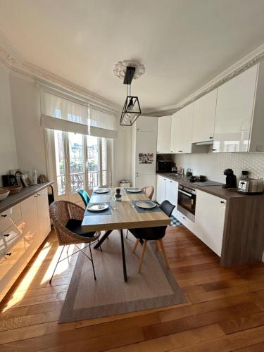 uma cozinha com uma mesa e cadeiras numa cozinha em Proche de Paris - 3 minutes du métro em Levallois-Perret