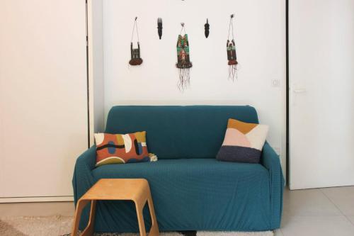 een blauwe bank in een woonkamer met kussens bij Studio with terrace near Paris in Boulogne-Billancourt