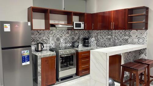 a kitchen with a stove and a refrigerator at Bellazio Aparthotel in Iquitos