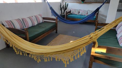 a hammock in a room with two chairs and a couch at AEROHOSTEL Brasil in Guarulhos