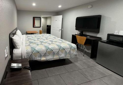 a hotel room with a bed and a flat screen tv at Motel 6 Englewood, FL in Englewood