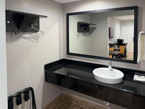 ein Badezimmer mit einem Waschbecken und einem großen Spiegel in der Unterkunft Motel 6 Englewood in Englewood