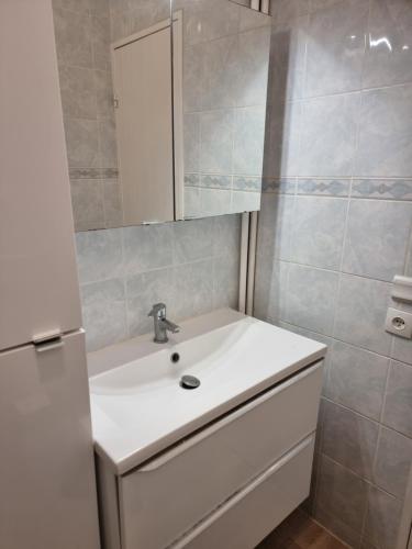 een badkamer met een witte wastafel en een spiegel bij Shared room next to Shopping mall and Train Station in Courcouronnes